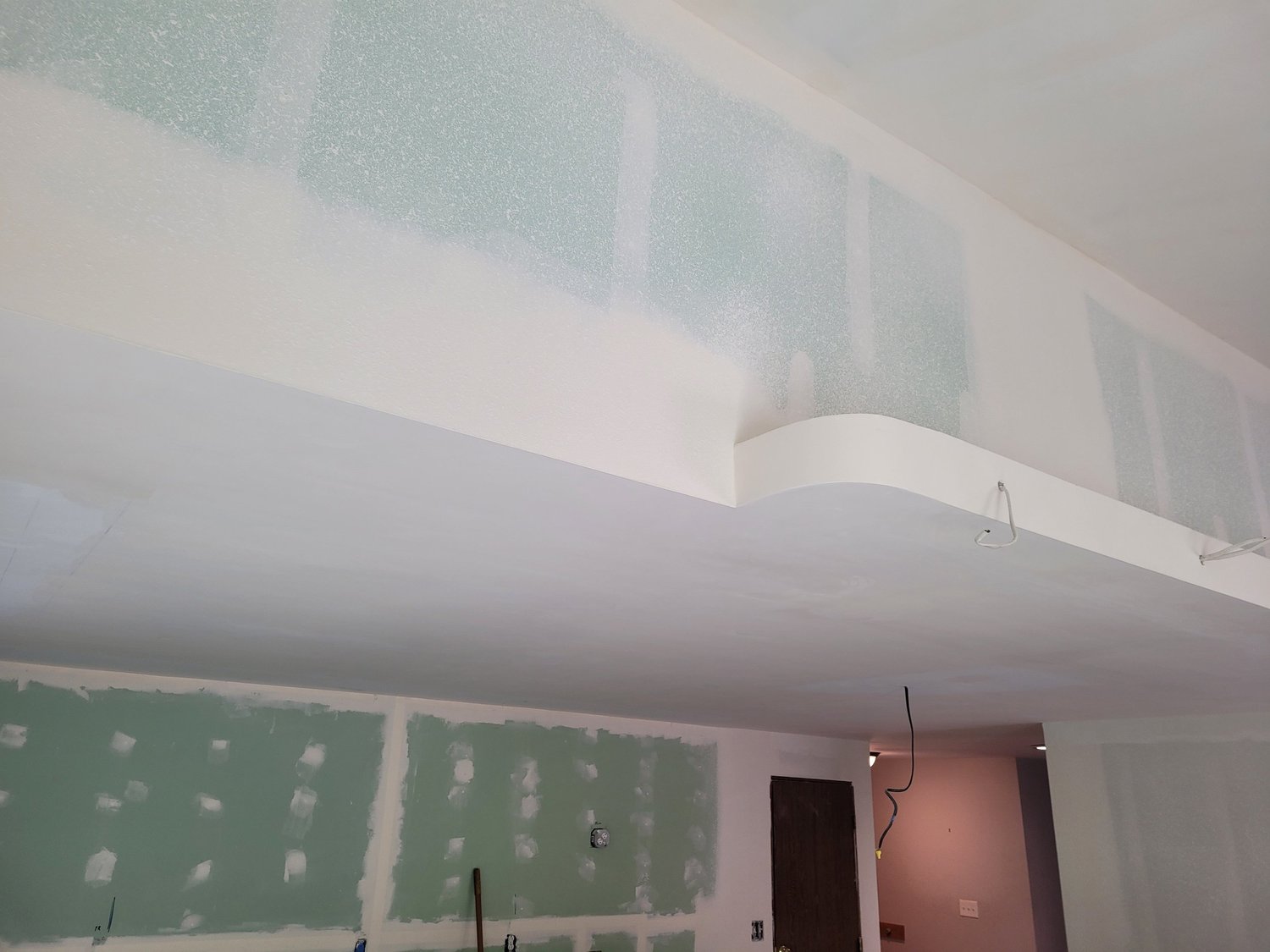 Drywall taping and finishing across a room and ceiling